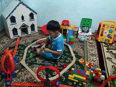 blind child playing, surrounded by tactile toys